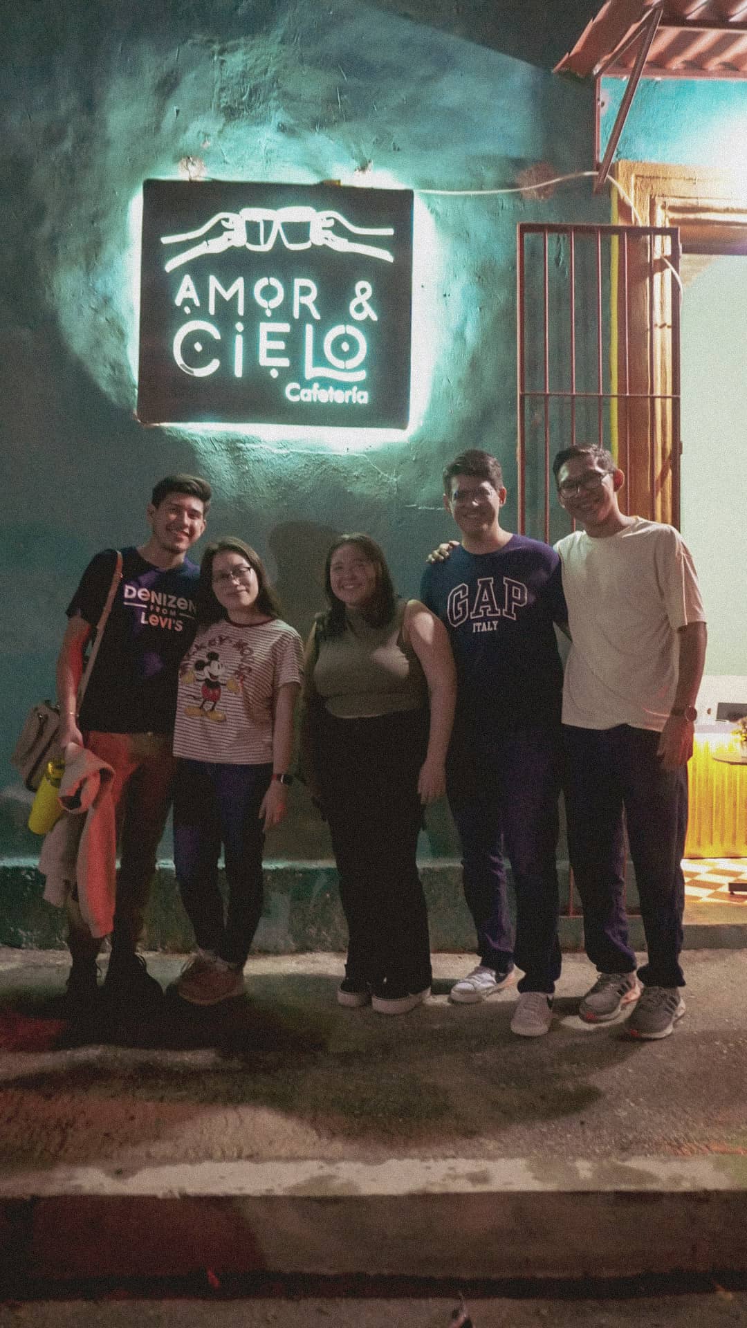 Clientes frente al letrero de Amor & Cielo de noche