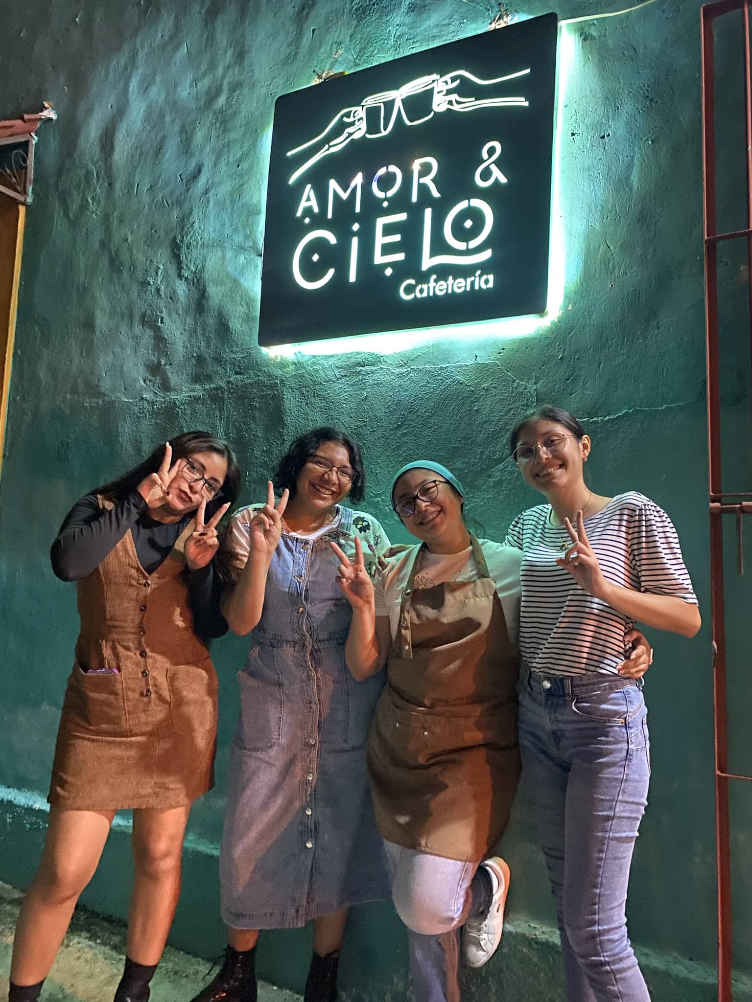 Grupo de clientas frente al letrero de noche
